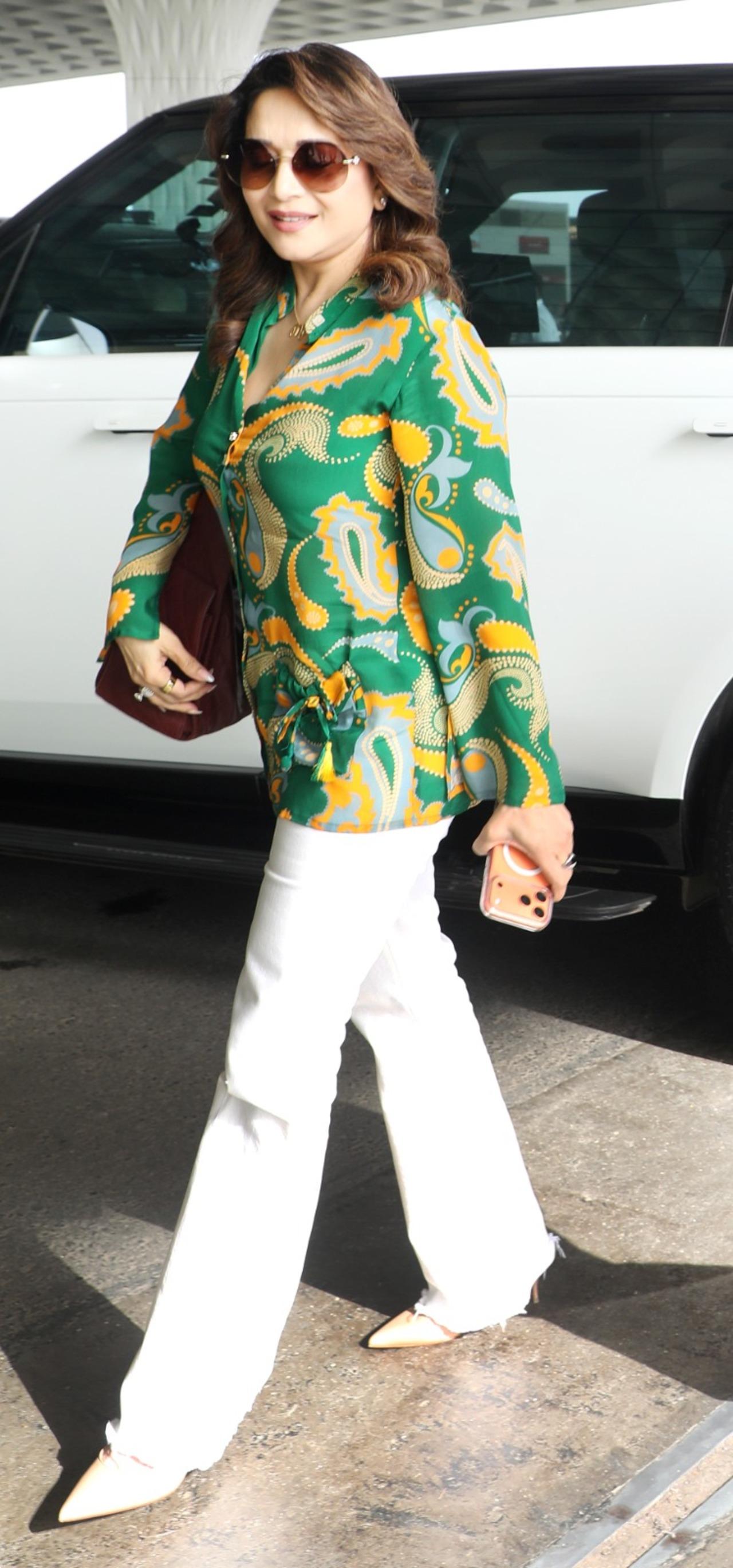 Madhuri looked chic in a printed shirt paired with white trousers and matching stilettos, a luxurious handbag and sunglasses.&nbsp;